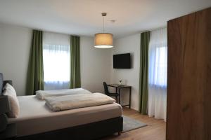 a bedroom with a bed and a table and a window at Kelsbachhaus OG in Pförring