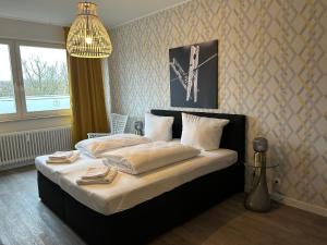 a bedroom with a bed with white sheets and a clock on the wall at Günstige Ferienwohnung 2 Pers zentral Hamburg BoLA 48 in Hamburg