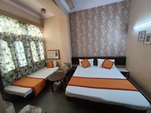 a hotel room with two beds and a window at Kailash Hotel in Jaipur