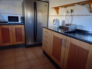 a kitchen with a refrigerator and a microwave at Casa Livia Pool & Sunset in Corralejo