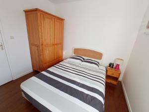 1 dormitorio con 1 cama y armario de madera en Gîte Le Coquillage, 50m de la mer, en Saint-Germain-sur-Ay