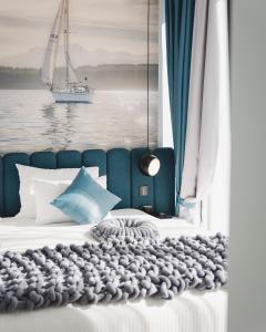 Hotel Aurel Coast في كوتور: غرفة نوم بسرير مع قارب شراعي في الماء