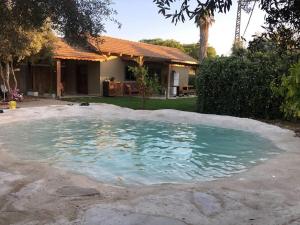 a pool of water in front of a house at משק נוי in Shoval 2