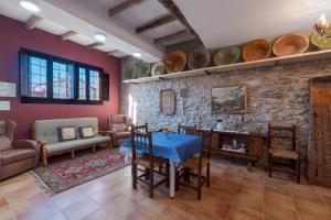 sala de estar con mesa, sillas y pared de piedra en CASA RURAL VICENTA 1750, en Albentosa