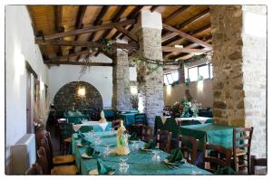 a dining room with green tables and chairs at Agriturismo Sant'Agata in Piana degli Albanesi