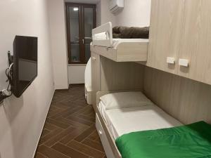 a small room with a bunk bed and a television at Casa Meravigliosa Fonseca in Naples +55 photos