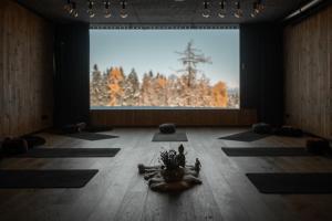 una stanza con tappetini per lo yoga sul pavimento di fronte a una grande finestra di Green Luxury Hotel Pfösl a Nova Ponente