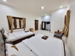 Postel nebo postele na pokoji v ubytování Ndalem Katong Guest House Ponorogo