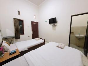 Voodi või voodid majutusasutuse Ndalem Katong Guest House Ponorogo toas