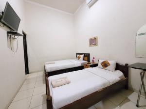 Voodi või voodid majutusasutuse Ndalem Katong Guest House Ponorogo toas
