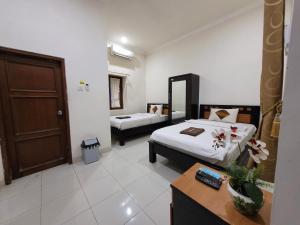 Voodi või voodid majutusasutuse Ndalem Katong Guest House Ponorogo toas