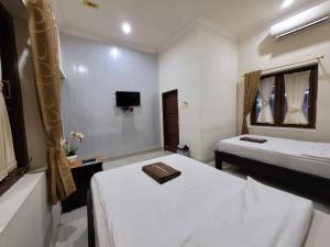 Voodi või voodid majutusasutuse Ndalem Katong Guest House Ponorogo toas