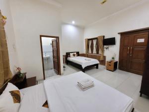 Voodi või voodid majutusasutuse Ndalem Katong Guest House Ponorogo toas