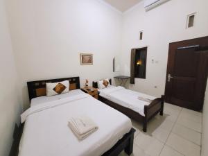 Voodi või voodid majutusasutuse Ndalem Katong Guest House Ponorogo toas