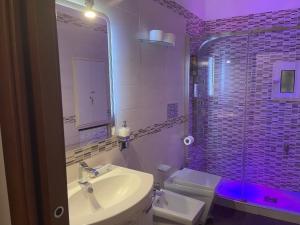 a bathroom with a sink and a toilet and a mirror at Casa Meravigliosa Fonseca in Naples