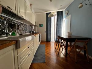 Una cocina con un fregadero y una mesa dentro. en A casa del Conte, en Palermo