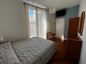 Un dormitorio con una cama y una ventana y un escritorio. en A casa del Conte, en Palermo