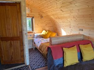 a bedroom with a bed in a wooden cabin at Manor Farm Stay in Sutton on Sea