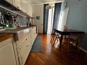 Una cocina con un fregadero y una mesa dentro. en A casa del Conte, en Palermo