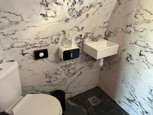 a bathroom with a white toilet and a sink at Manor Farm Stay in Sutton on Sea