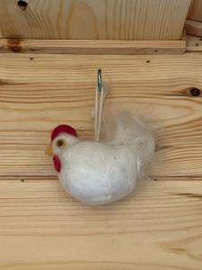 a white chicken is sitting on a wooden table at Manor Farm Stay in Sutton on Sea