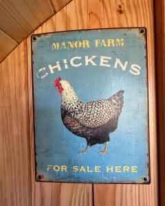 a sign with a chicken on a wooden wall at Manor Farm Stay in Sutton on Sea