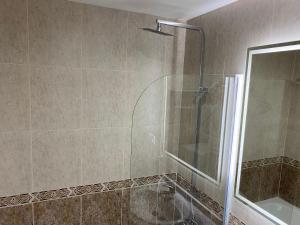 een badkamer met een douche en een glazen deur bij SANTA MARTA PLAYA BAIONA in Baiona