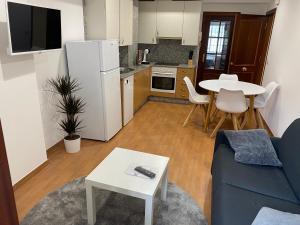 a living room with a blue couch and a kitchen at SANTA MARTA PLAYA BAIONA in Baiona
