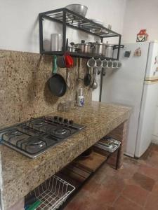 a kitchen counter with a stove and a refrigerator at Villa Isabel in Guaduas