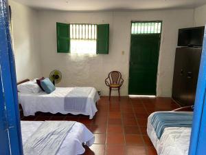 um quarto com duas camas e uma cadeira em Villa Isabel em Guaduas