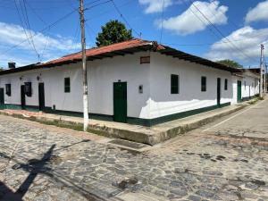 a white building with a green door on a street at Villa Isabel in Guaduas