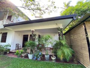 a house with plants in front of it at Unawatuna House in Unawatuna