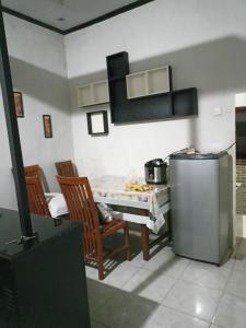 eine Küche mit einem Kühlschrank und einem Tisch mit Stühlen in der Unterkunft pandya Bromo in Pasuruan