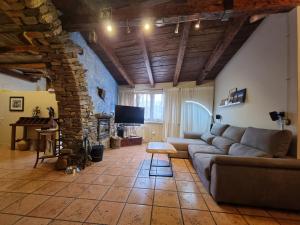 a living room with a couch and a stone fireplace at BAJOS CON ENCANTO EN RIALP in Rialp