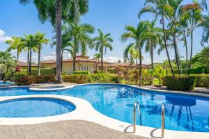 una piscina con palmeras frente a una casa en Costa del Sol 66, en Esterillos