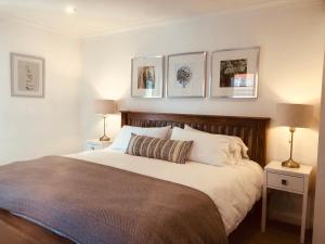 a bedroom with a large bed with three pictures on the wall at Websters Bed & Breakfast in Salisbury