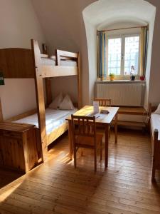 a room with two bunk beds and a table and chairs at Kloster Wernberg in Wernberg