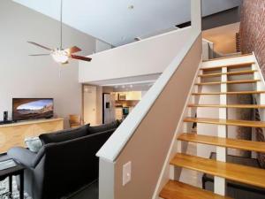 a living room with a staircase and a couch at Large Condo in Downtown Memphis in Memphis