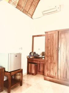a room with a wooden desk and a mirror at Jona Bungalow in Nusa Penida