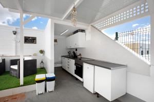 a kitchen with white cabinets and a large window at Buena Fuerte Apartamentos Marino in Tarajalejo