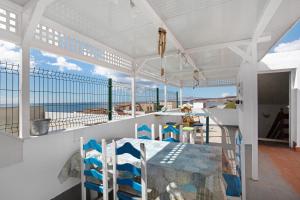 a balcony with a table and chairs on the beach at Buena Fuerte Apartamentos Marino in Tarajalejo