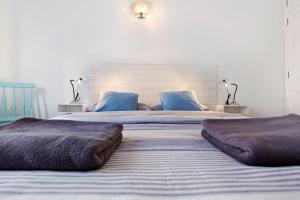 a bedroom with two large beds with blue pillows at Buena Fuerte Apartamentos Marino in Tarajalejo