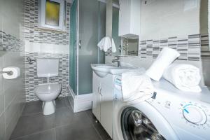 a washing machine in a bathroom with a toilet at Apartments Kresimir in Ražanj