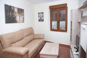 uma sala de estar com um sofá e uma mesa de centro em Casa rural fuenteciruelos em Guzmán