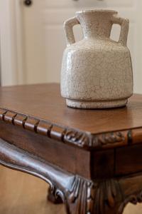 um vaso sentado em cima de uma mesa de madeira em Althaia Pension em Nafplio