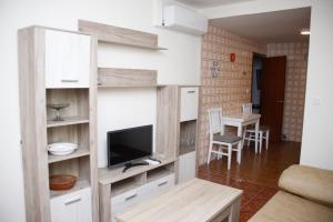 een woonkamer met een tv aan de muur bij Casa rural fuenteciruelos in Guzmán