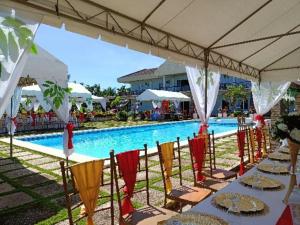a table set up for a wedding in front of a pool at Calicoan Villa in Sarog
