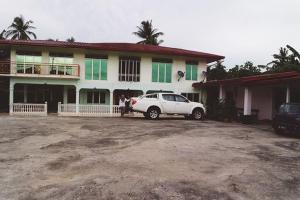 un coche blanco estacionado frente a una casa en Muna’s Homestay en Kota Belud