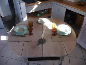 una mesa de madera en una cocina con tazones y vasos. en Rendez-vous au jardin, en Notre Dame-de-lʼOsier