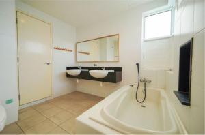 Nautilus Bay Home Inn في جورج تاون: حمام مع مغسلتين وحوض استحمام